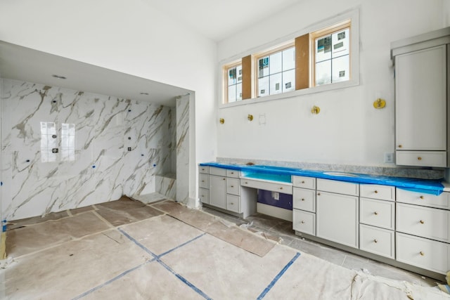 bathroom featuring vanity and tile walls