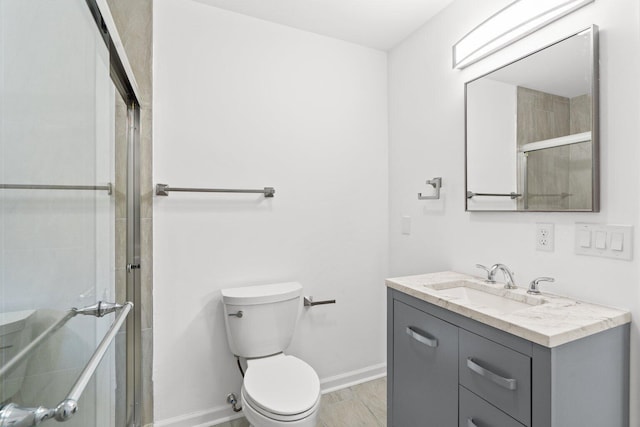 bathroom with vanity, an enclosed shower, and toilet