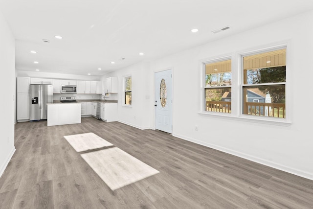 unfurnished living room featuring sink and light wood-type flooring