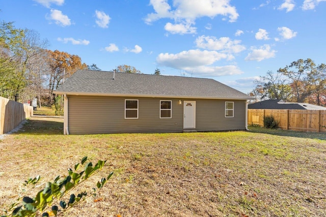 rear view of house featuring a lawn