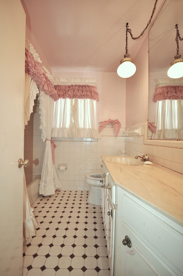 full bathroom with shower / bath combination with curtain, vanity, toilet, and tile walls