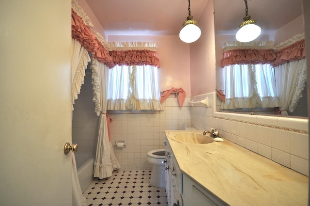 full bathroom featuring vanity, tile patterned floors, toilet, shower / bath combo with shower curtain, and tile walls