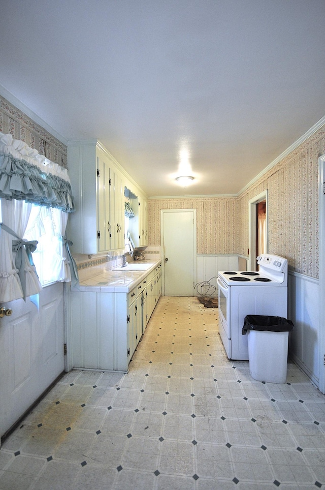 kitchen featuring washer / dryer, sink, white electric range oven, and ornamental molding