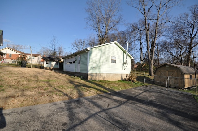 view of front facade with a garage, a storage shed, and a front lawn