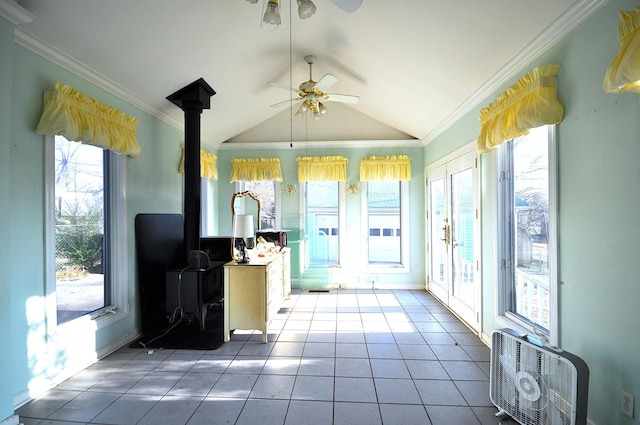 kitchen featuring a wood stove, crown molding, a wealth of natural light, and vaulted ceiling