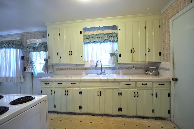 kitchen featuring tile countertops, white range with electric stovetop, and sink