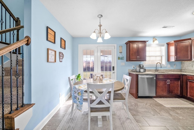 kitchen featuring stainless steel dishwasher, a notable chandelier, hanging light fixtures, and sink