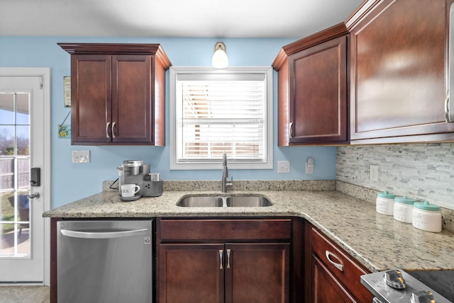 kitchen with appliances with stainless steel finishes, decorative backsplash, light stone counters, and sink