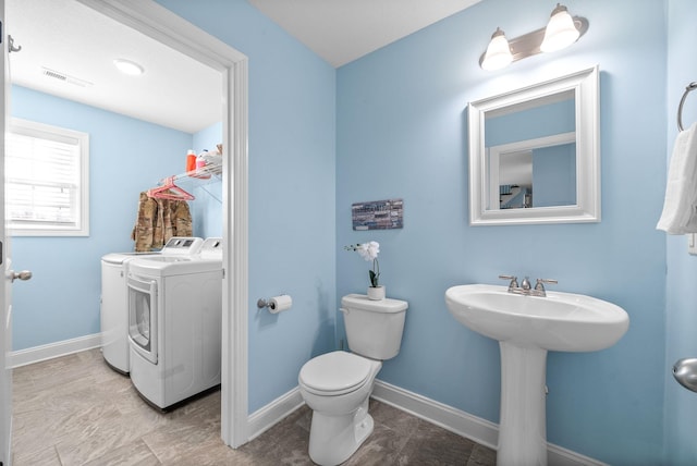 bathroom with toilet, sink, and independent washer and dryer