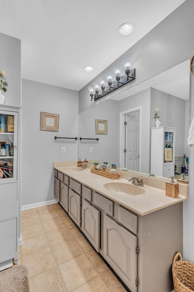 bathroom featuring double vanity, recessed lighting, a sink, and baseboards