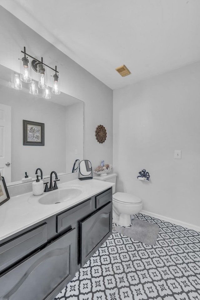 bathroom with tile patterned flooring, vanity, and toilet