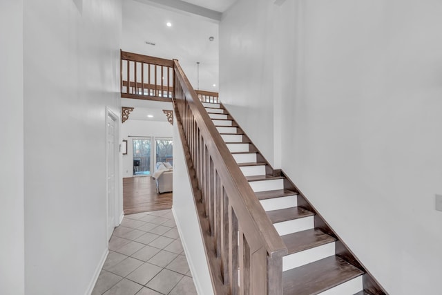 stairway with tile patterned flooring, a high ceiling, baseboards, and recessed lighting