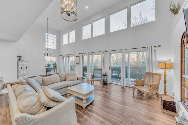 living room featuring a high ceiling, hardwood / wood-style flooring, and an inviting chandelier