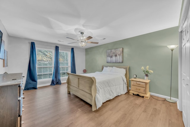 bedroom featuring light wood-style floors, ceiling fan, and baseboards