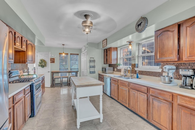 kitchen featuring a healthy amount of sunlight, stainless steel appliances, a sink, and light countertops