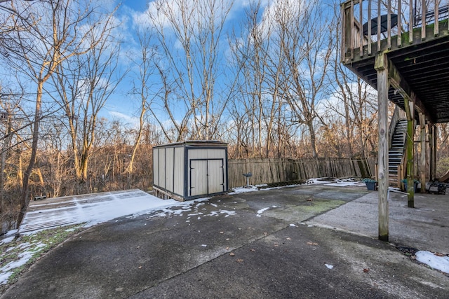 snow covered patio with a shed