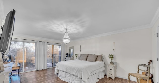 bedroom featuring crown molding, an inviting chandelier, wood finished floors, and access to exterior