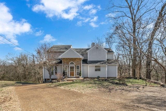 view of front of property with stone siding and a chimney