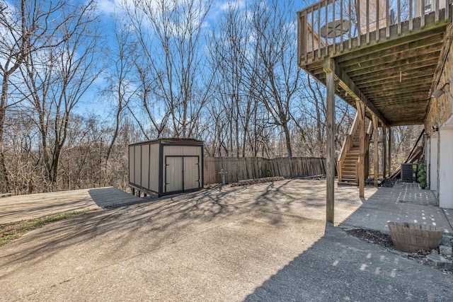 view of yard featuring an outdoor structure, stairway, a storage shed, and fence