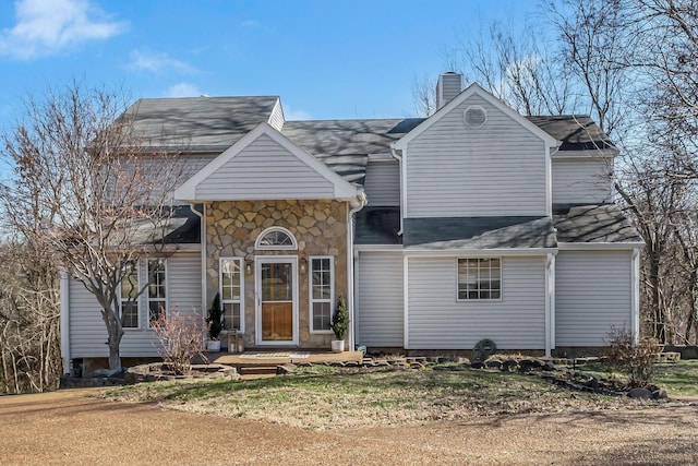 view of front of property with stone siding and a chimney