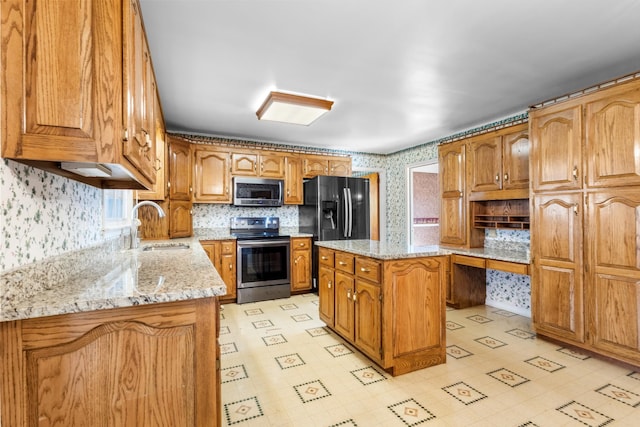 kitchen featuring a kitchen island, sink, light stone countertops, and stainless steel appliances