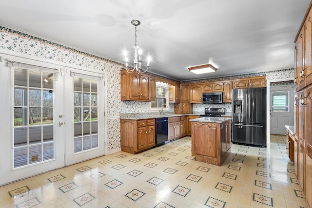 kitchen with plenty of natural light, a center island, stainless steel appliances, and decorative light fixtures