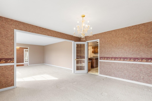 unfurnished room with carpet floors and a notable chandelier