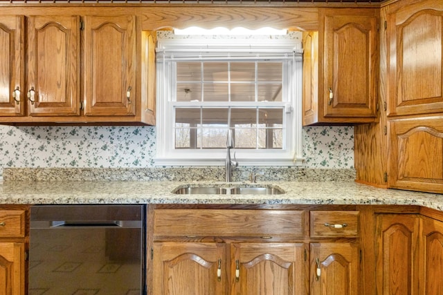 kitchen featuring stainless steel dishwasher, light stone countertops, sink, and tasteful backsplash