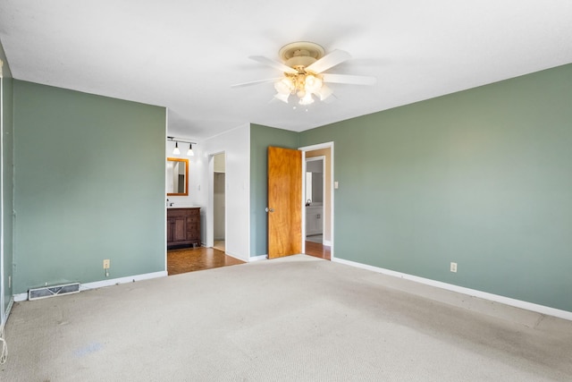 unfurnished bedroom featuring ensuite bath, ceiling fan, and carpet