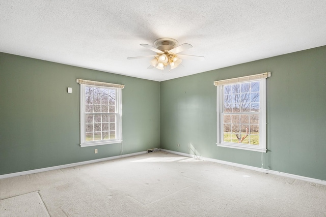 carpeted empty room with a textured ceiling, ceiling fan, and a healthy amount of sunlight