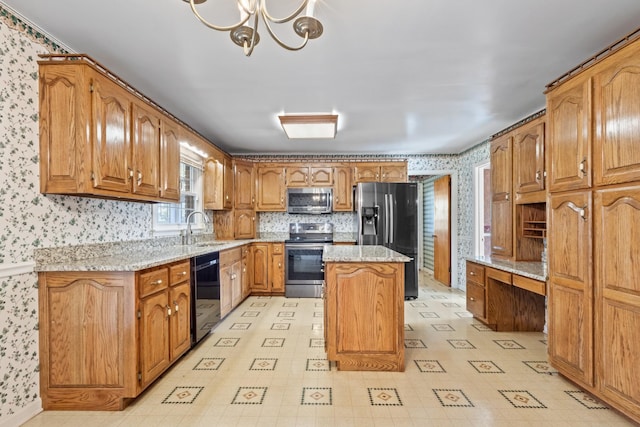 kitchen featuring an inviting chandelier, sink, appliances with stainless steel finishes, a kitchen island, and light stone counters