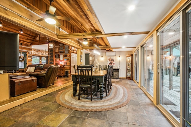 dining space with ceiling fan and beamed ceiling