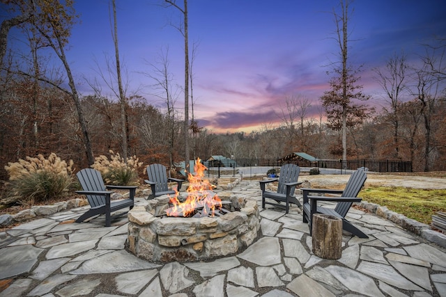 patio terrace at dusk featuring an outdoor fire pit