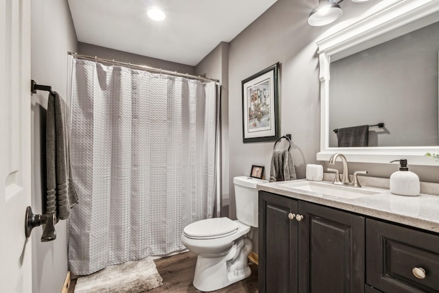 bathroom with hardwood / wood-style flooring, vanity, toilet, and a shower with curtain