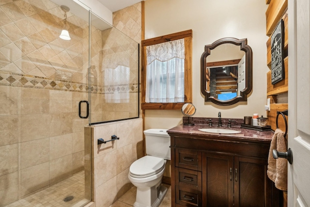 bathroom featuring vanity, tile patterned flooring, a shower with shower door, and toilet