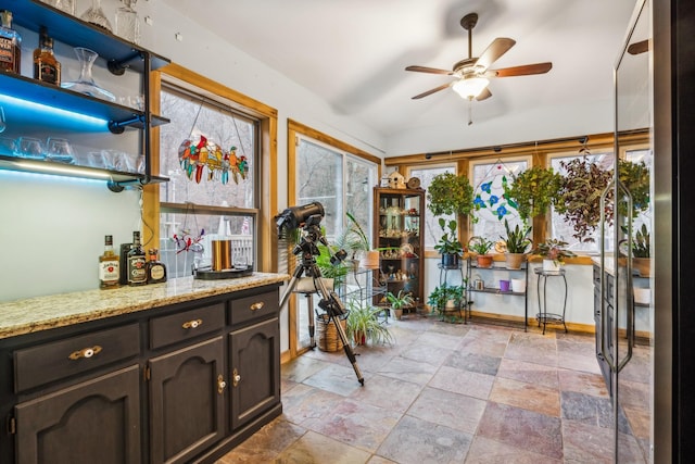 interior space with lofted ceiling, ceiling fan, and indoor bar