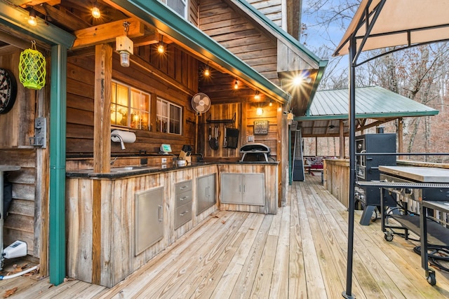 wooden terrace with a grill, sink, and exterior kitchen