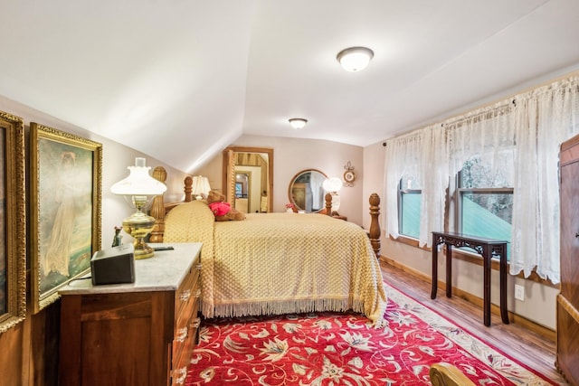 bedroom featuring hardwood / wood-style floors and vaulted ceiling