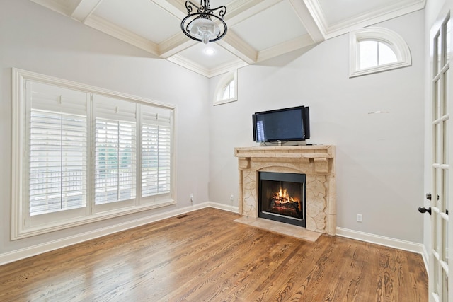 unfurnished living room featuring beam ceiling, a wealth of natural light, and coffered ceiling