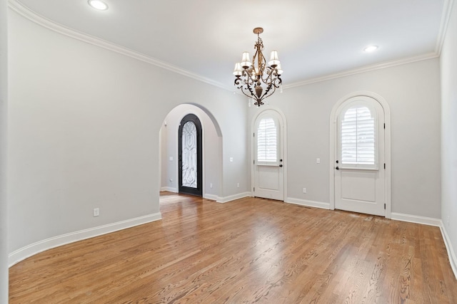 entryway with light hardwood / wood-style floors, crown molding, and a notable chandelier