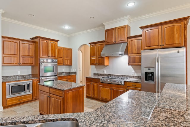 kitchen featuring crown molding, light tile patterned floors, stainless steel appliances, and dark stone counters