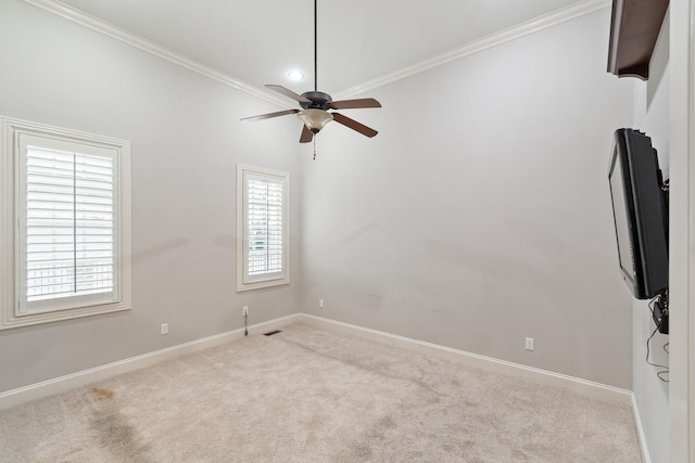 carpeted empty room with ceiling fan and crown molding