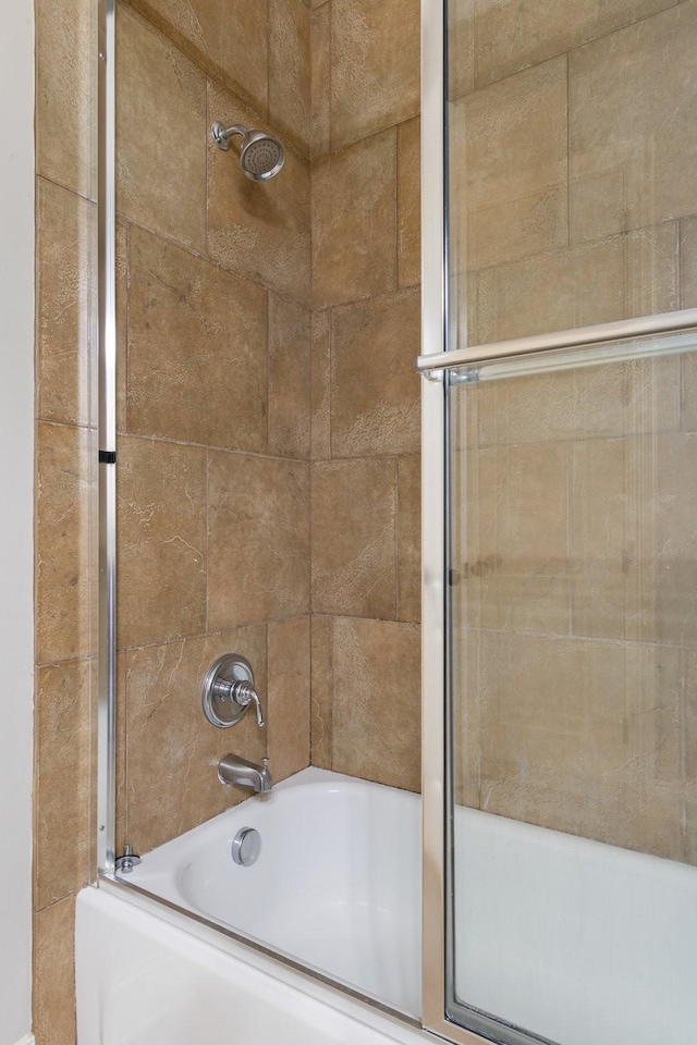 bathroom with combined bath / shower with glass door