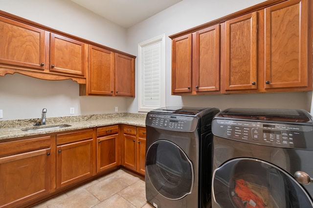 clothes washing area featuring cabinets, washing machine and dryer, light tile patterned floors, and sink