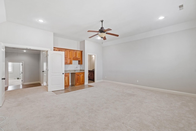 unfurnished living room with light carpet and ceiling fan