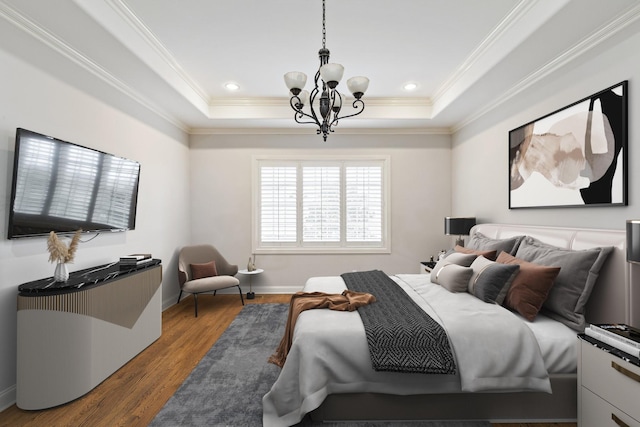 bedroom featuring a raised ceiling, hardwood / wood-style floors, a chandelier, and ornamental molding