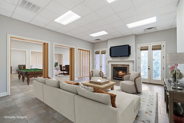 living room featuring a fireplace, french doors, a drop ceiling, and billiards