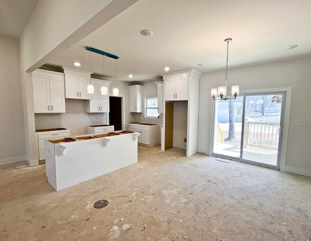 kitchen featuring hanging light fixtures, white cabinets, a notable chandelier, and a center island