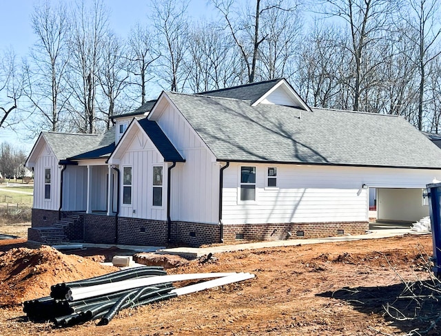 view of home's exterior with roof with shingles, crawl space, and board and batten siding