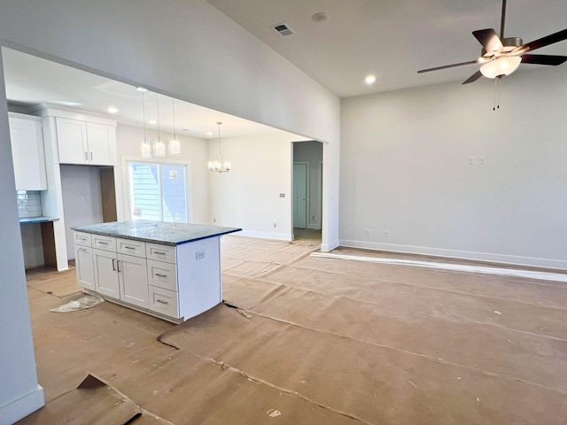 kitchen with open floor plan, pendant lighting, white cabinetry, and a center island